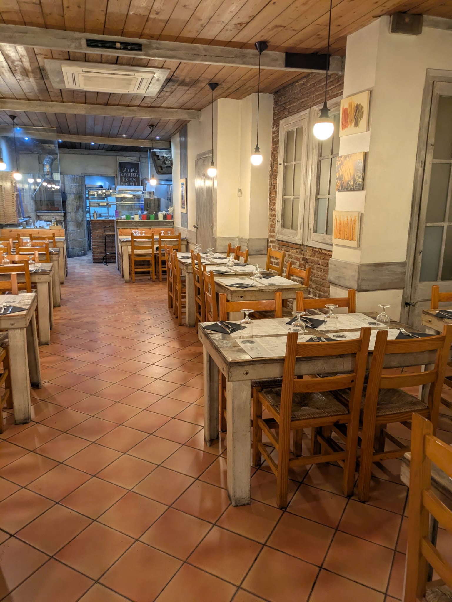 Interior del restaurant La Pentola — sala principal amb taules de fusta i ambient càlid